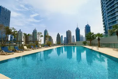 a large swimming pool with a city skyline in the background at Gala Guests - Iris Blue Luxe Living Collection in Dubai