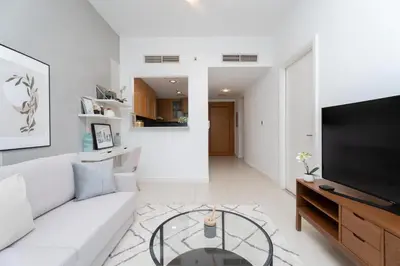 a living room with a white couch and a glass table at Gala Guests - Iris Blue Luxe Living Collection in Dubai