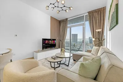a living room with a couch and a tv at Waves - Vibrant and Cozy 1BR Apt in JVC in Dubai