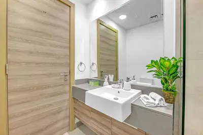 a bathroom with a sink and a mirror at Waves - Vibrant and Cozy 1BR Apt in JVC in Dubai