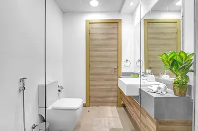 a bathroom with a toilet and a sink and a mirror at Waves - Vibrant and Cozy 1BR Apt in JVC in Dubai