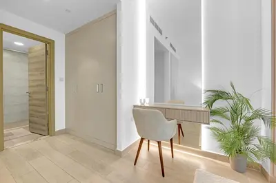 a hallway with a desk and a chair and a plant at Waves - Vibrant and Cozy 1BR Apt in JVC in Dubai