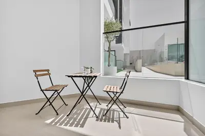 two chairs and a table in front of a window at Dusk by Binghatti by Rentujemy in Dubai