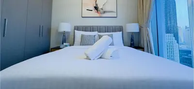a bedroom with a large white bed with a window at Downtown Gem Apt, Burj View Bliss in Dubai