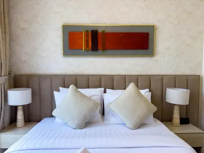 a bed with white pillows and a painting on the wall at Downtown Gem Apt, Burj View Bliss in Dubai