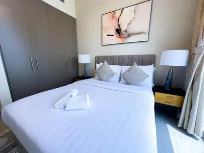 a bedroom with a large white bed with two lamps at Downtown Gem Apt, Burj View Bliss in Dubai