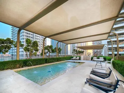 a swimming pool with lounge chairs next to a building at KeyRock - Palm View Apt with Pool & Gym Access in Dubai