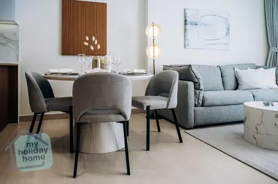 a living room with a table and a couch at Brand New 1BR Fully Furnished in Dubai