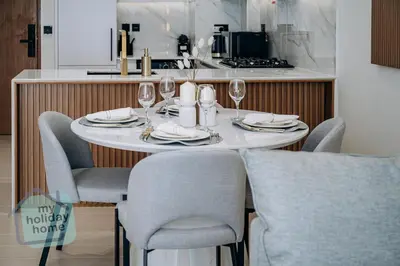 a dining room table with chairs and wine glasses at Brand New 1BR Fully Furnished in Dubai
