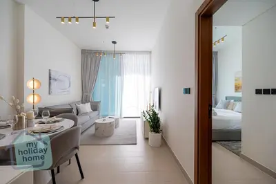 a living room with a bed and a dining room at Brand New 1BR Fully Furnished in Dubai