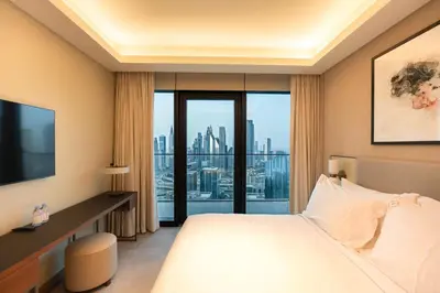 a hotel room with a bed and a large window at Venetian - Sky 3BR - Address Opera with Burj & Fountain views in Dubai