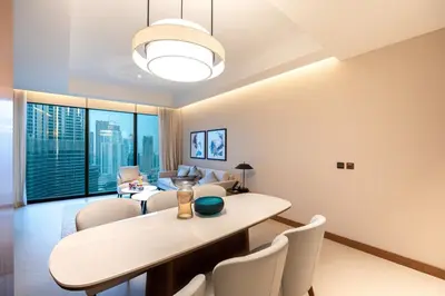 a living room with a dining table and chairs at Venetian - Sky 3BR - Address Opera with Burj & Fountain views in Dubai