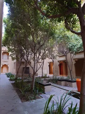 a courtyard with trees and a building at 5 Star Burj Khalifa View Spacious 2BR Next to Dubai Mall in Dubai