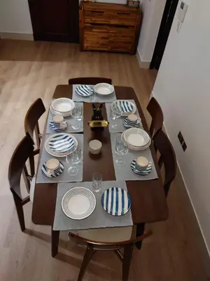 a wooden table with plates and glasses on it at 5 Star Burj Khalifa View Spacious 2BR Next to Dubai Mall in Dubai