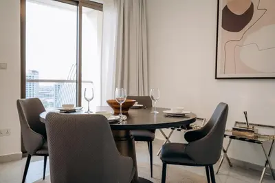 a dining room with a table and chairs and a window at Top Holiday Location - Canal View - Beach Access in Dubai