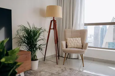 a living room with a floor lamp and a chair at Top Holiday Location - Canal View - Beach Access in Dubai
