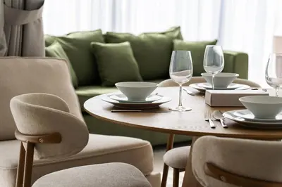 a dining room table with wine glasses and a couch at SettlerHomes - Liv Marina Luxe With Gym, Pool, Sauna in Dubai