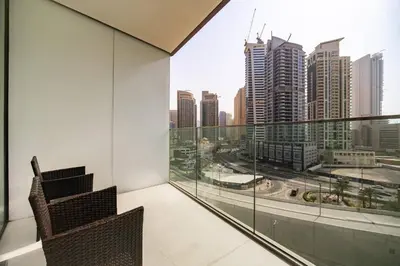 a balcony with two chairs and a view of the city at SettlerHomes - Liv Marina Luxe With Gym, Pool, Sauna in Dubai