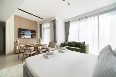 a hotel room with a bed and a dining room at SettlerHomes - Liv Marina Luxe With Gym, Pool, Sauna in Dubai