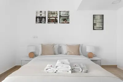 a bedroom with a white bed with towels on it at Beautiful Studio Prime location Pool & Gym in Dubai