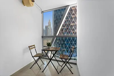 a balcony with a table and chairs in front of a window at Beautiful Studio Prime location Pool & Gym in Dubai