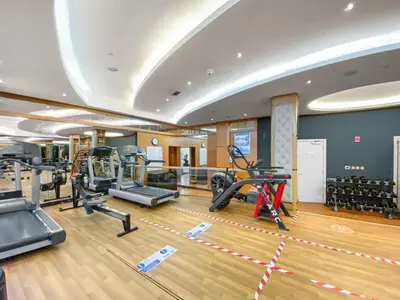 a gym with treadmills and cardio equipment in a room at Beautiful Studio Prime location Pool & Gym in Dubai