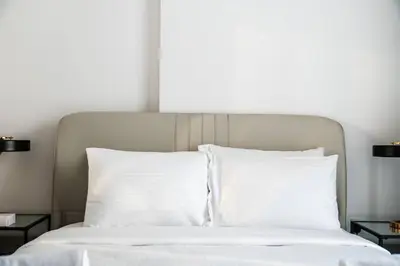 a white bed with white pillows and two night stands at SettlerHomes - Lux 20F Stay With Gym, Pool & Cinema in Dubai
