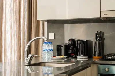 a kitchen with a counter top with a bottle of water at SettlerHomes - Lux 20F Stay With Gym, Pool & Cinema in Dubai