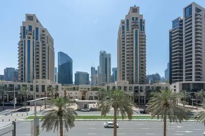 a city skyline with palm trees in a parking lot at RBA Holidays - Luxury Studio near Burj Khalifa - Downtown Dubai in Dubai