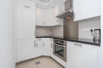 a kitchen with white cabinets and a sink at RBA Holidays - Luxury Studio near Burj Khalifa - Downtown Dubai in Dubai