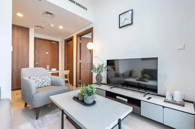 a living room with a tv and a couch and a table at City View with Balcony Next to Dubai Water Canal, Walking Distance to Marine Transport Station, Easy Downtown Access, Reva Residences, Business Bay by Deluxe Holiday Homes in Dubai