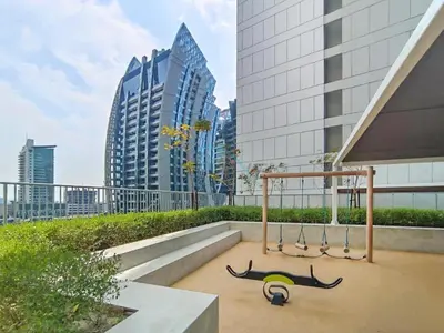 a group of swings in a city with tall buildings at City View with Balcony Next to Dubai Water Canal, Walking Distance to Marine Transport Station, Easy Downtown Access, Reva Residences, Business Bay by Deluxe Holiday Homes in Dubai