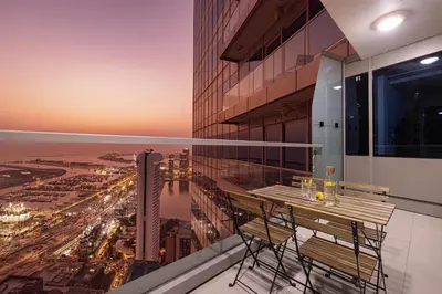 a balcony with a table and chairs on a building at Sea & City View Apartment Dubai Marina - Ravello Living in Dubai