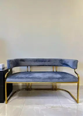 a blue bench with gold legs sitting on a floor at Comfortable Studio Living in Dar Al Jawhara, JVC in Dubai