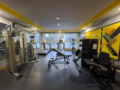 a gym with several treadmills and machines in a room at Comfortable Studio Living in Dar Al Jawhara, JVC in Dubai