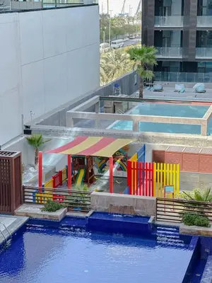a view of a pool with a playground at Comfortable Studio Living in Dar Al Jawhara, JVC in Dubai