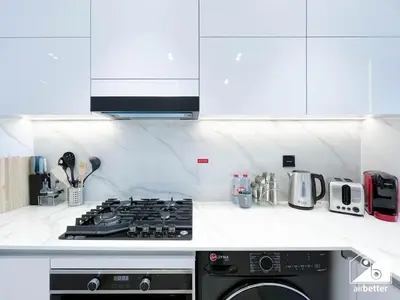 a kitchen with a stove and a stove top oven at Luxury 1BR l Balcony, Pool, Gym & Prime Location in Dubai