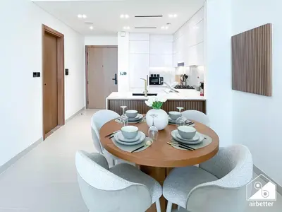 a dining room with a wooden table and chairs at Luxury 1BR l Balcony, Pool, Gym & Prime Location in Dubai