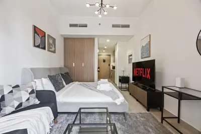 a bedroom with a bed and a couch and a tv at Elite Escape - Getaway in Azizi Riviera 26 in Dubai
