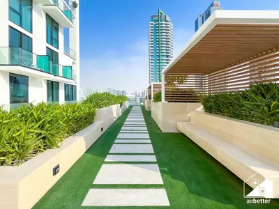 a walkway in the middle of a building with plants at Dubai JVC 1BR l Stylish Stay with Top Amenities in Dubai