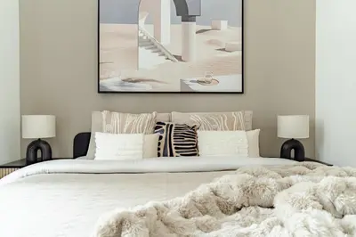 a bedroom with a large white bed with a blanket at The Smart Concierge - Marina Wharf in Dubai
