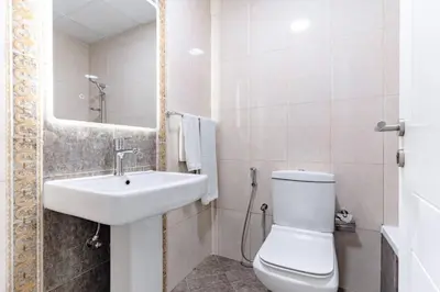 a white bathroom with a sink and a toilet at The Smart Concierge - Marina Wharf in Dubai