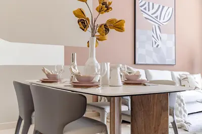 a dining room table with a vase with yellow flowers at The Smart Concierge - Burj Views in Dubai