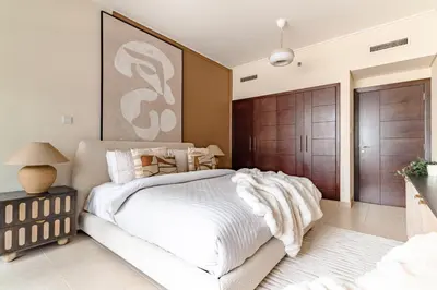 a bedroom with a white bed and a wooden door at The Smart Concierge - Burj Views in Dubai