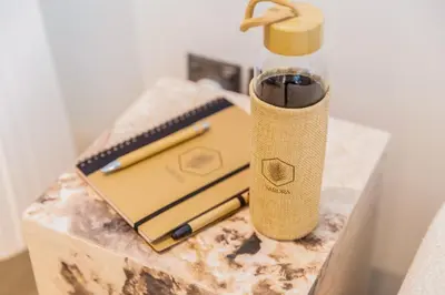 a briefcase and a bottle on a marble table at Sarora One - Japandi-Inspired 2-Bedroom Apartment in Act One, Downtown Dubai with Balcony & Burj Khalifa View in Dubai
