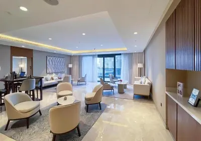a hotel room with a lobby with chairs and a table at Sarora One - Japandi-Inspired 2-Bedroom Apartment in Act One, Downtown Dubai with Balcony & Burj Khalifa View in Dubai