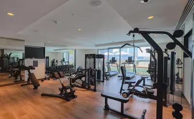a gym with a lot of treadmills and machines at Sarora One - Japandi-Inspired 2-Bedroom Apartment in Act One, Downtown Dubai with Balcony & Burj Khalifa View in Dubai
