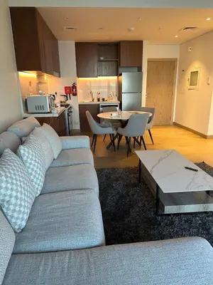 a living room with a blue couch and a kitchen at 2BR Apartment with full sea view & Burj Khalifa in Dubai