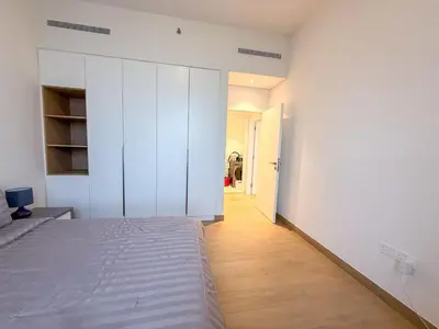 a white bedroom with a bed and a hallway at 2BR Apartment with full sea view & Burj Khalifa in Dubai