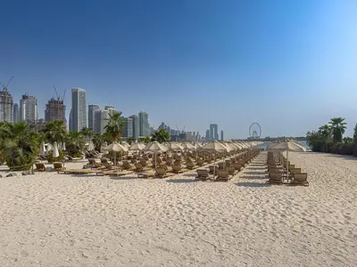 a row of beach chairs and umbrellas on a beach at Seven Palm Jumeirah Studio - Private Beach Access in Dubai